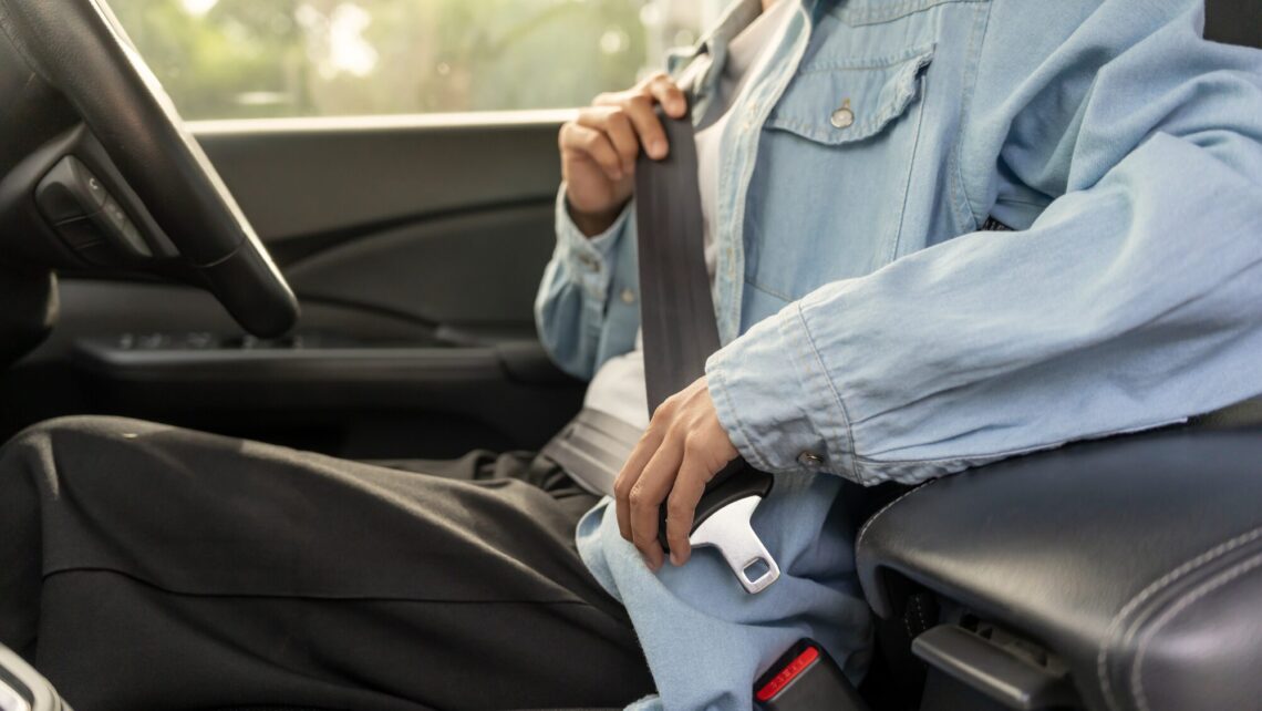 person buckling up before defensive driving test